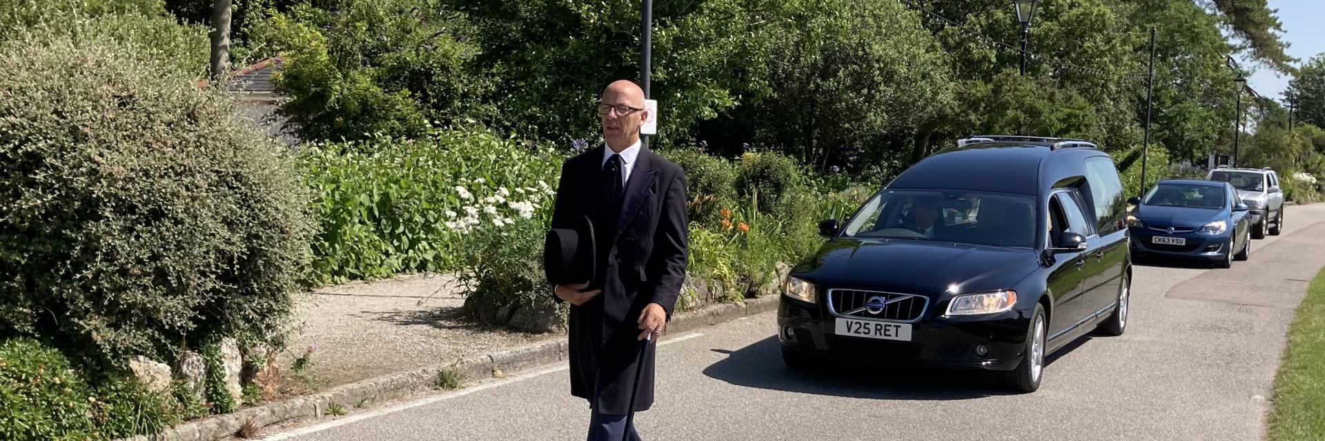 Funeral Director walking in front the funeral cortege